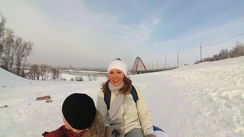 happy family rides and smiling snowtube on snowy roads.slow motion. snow winter landscape. outdoors sports