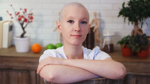 Portrati of a happy cancer survivor woman sitting on a chair, smiling and looking into the camera