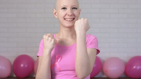 Happy breast cancer survivor woman fighting breast cancer making boxer's punches -breast cancer awareness concept
