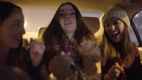 Group Of Friends Celebrate In Backseat Of Moving Car, They Make Up A Dance Move Together And Laugh