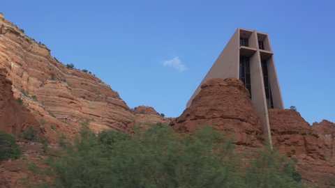 Chapel of the Holy Cross: Sedona, Arizona - October 25, 2016 - A wide shot driving by the exterior of the Church on a bright day. The sun plays off the rocks and facade of the building.