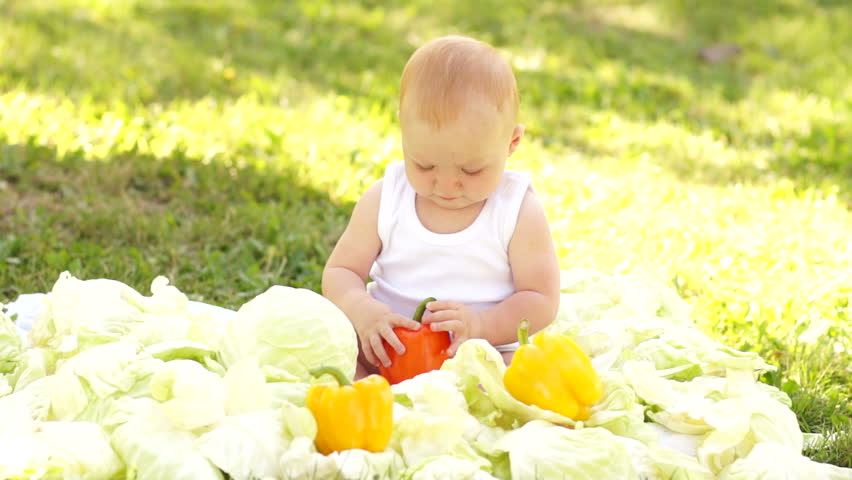 Newborn baby girl in the vegetables outdoors