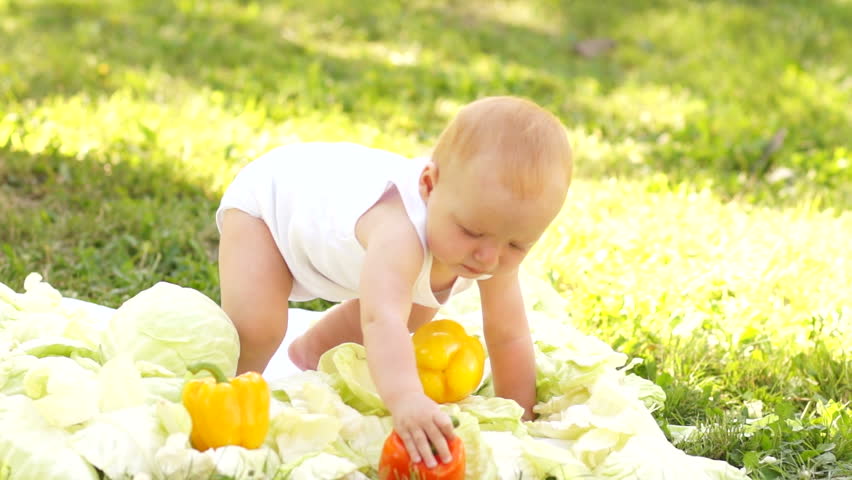 New born trying to walk. Baby in the vegetables