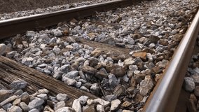 Cinematic scene of female walk on old train rails in slow motion 1080p FullHD footage - Casual clothed woman steps on railroad ties and stone slow-mo 1920X1080 HD video