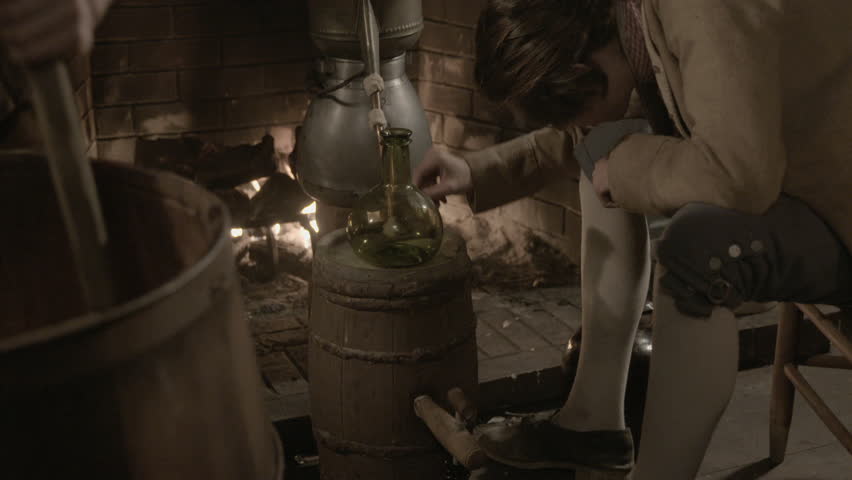VIRGINIA - SUMMER 2016 - Reenactment, Recreation, old Tavern, saloon, bar before fireplace - 18th / 19th man works century alcohol distillery, still - copper pipes, mash and rum bottles. Gin, whiskey 