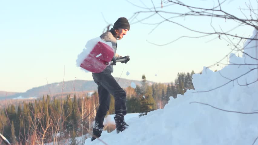Man removing snow from the roof with a shovel