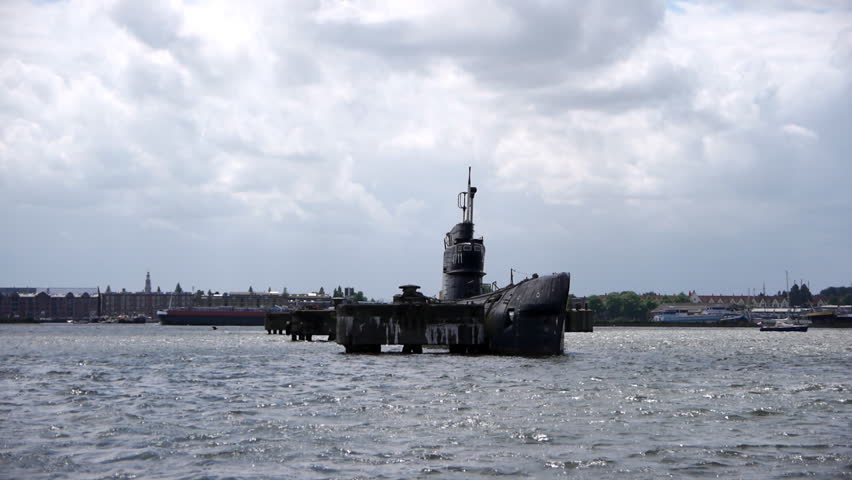 Submarine in harbour with Amsterdam in the distance.
