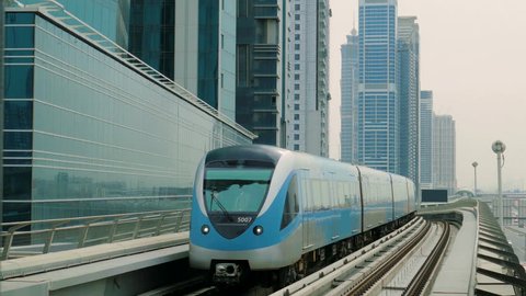 The subway train rides among the glass skyscrapers in Dubai, UAE