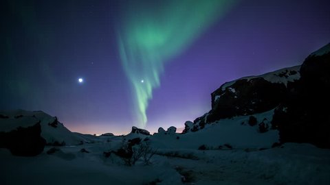 Aurora borealis moving over snow covered volcanic terrain Reykjavik Iceland