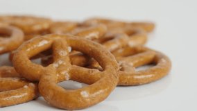 Baked pretzel snack close-up on white background 4K 2160p 30fps UltraHD tilting footage - Tasty bread product made from dough slow tilt 3840X2160 UHD video