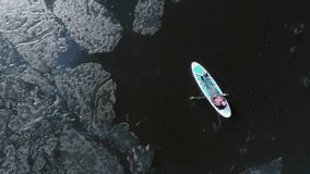 Aerial view of two athletes on the SUP. Winter. Ice.