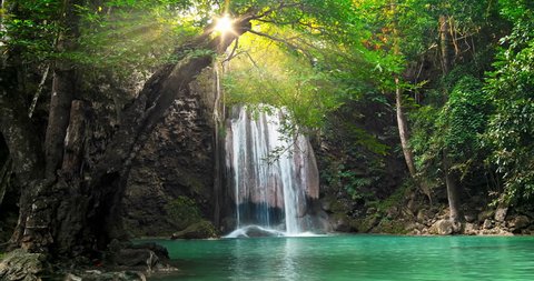 Majestic waterfall and beautiful tropical nature with sun light shining through tree branches in Erawan national park, Kanchanaburi, Thailand