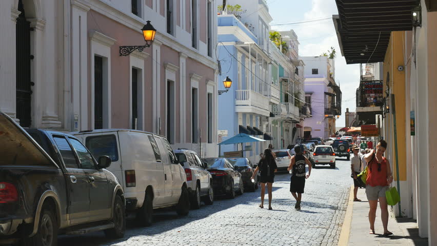 SAN JUAN, PUERTO RICO-FEBRUARY 2017: Auto and pedestrian traffic on narrow city street scene in the Caribbean vacation destination of  Old Town San Juan, Puerto Rico