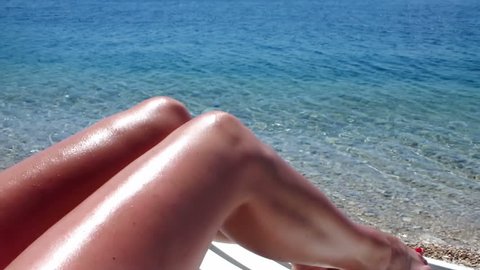 beautiful tanned women's legs at the beach