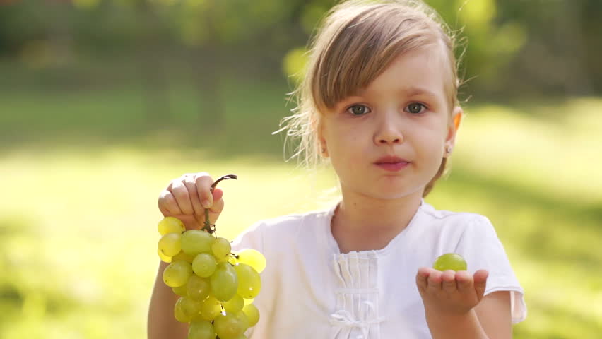 Little girl holding grapes