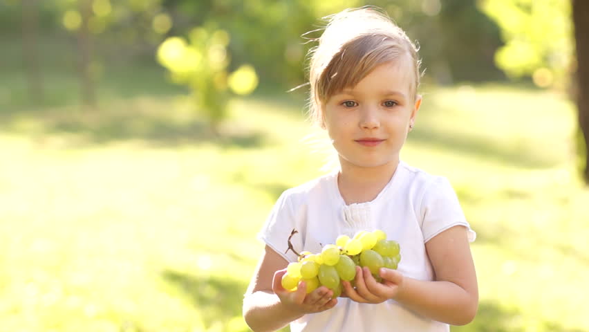 Portrait of happy little girl with grapes