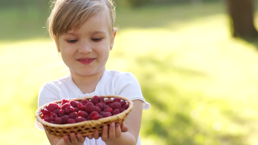 Beautiful girl with a basket of raspberries 