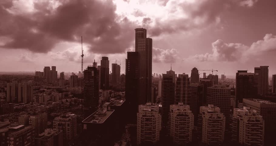 Vertical ascent movement of Aerial view of tel aviv skyline with urban skyscrapers at sunset, with cloudy sky, Israel
