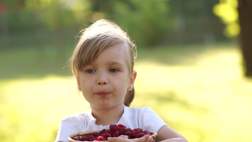 Closeup portrait girl with basket of raspberry and thumbs up. Sign Ok