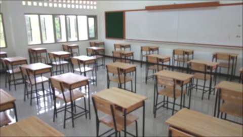 blurred of school classroom with desks chair wood, and blackboard in high school thailand, vintage tone education concept