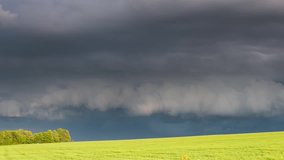 Alarming view of the vivid lawn and dark ominous clouds. Dramatic and mystery scene. Wonderful natural background. Beauty world. Climate change. Time lapse clip, interval shooting in HD 1080 video.