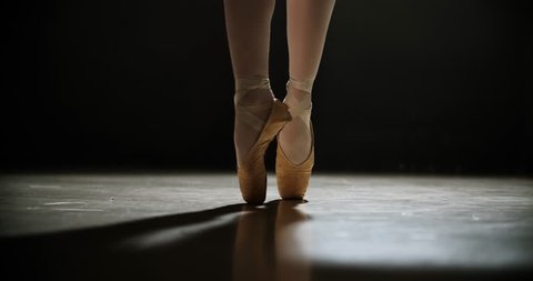Close-up of ballerina feet in pointe shoes during dance, slow motion