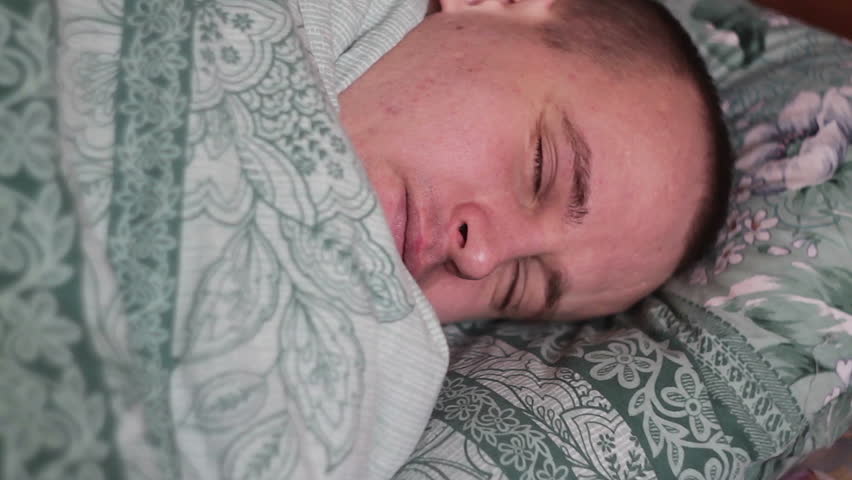 Close-up shot of young man in bed at home sleeping.