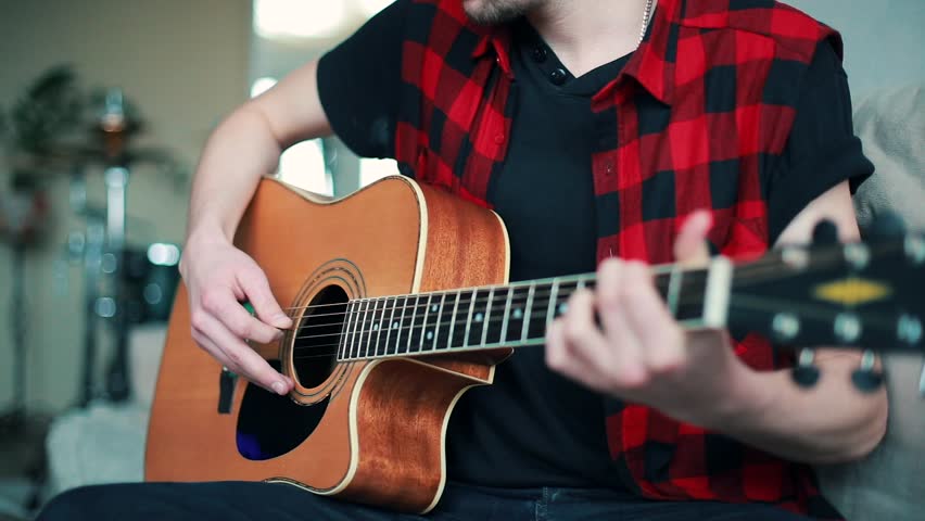 Young musician guy playing the guitar