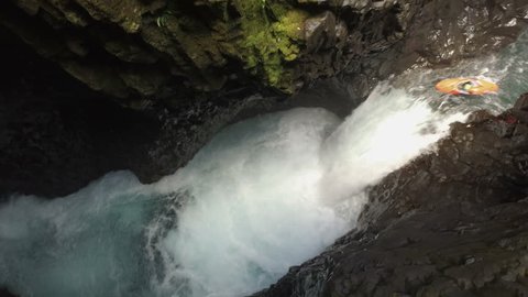 Aerial - Extreme kayaker paddling off a waterfall in a tight canyon - Canada