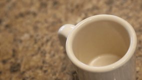 Slow Motion of Pouring Coffee Into Mug in Kitchen With Room For Text. Clip Continues as Bubbles Float and Pop.