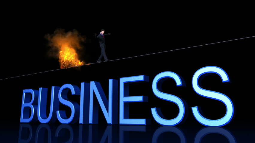 Businessman walks tightrope on fire