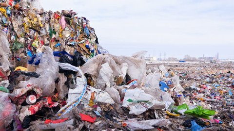 Big piles of garbage. Plastic, packages, polyethylene in a garbage dump. Dolly shot.