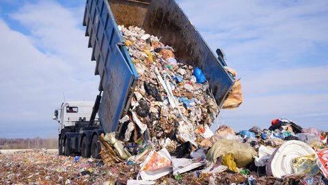 Garbage truck disposed trash on the landfill. Vehicle transporting garbage to waste.