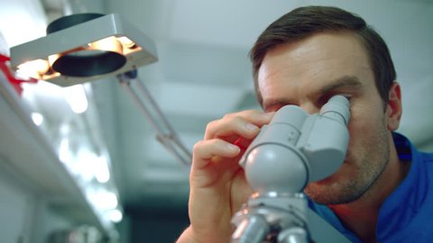 Male doctor microscope. Close up of doctor scientist looking through microscope. Lab worker looking medical microscope. Microscope man face