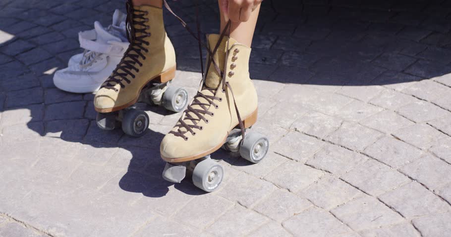 Crop female putting on roller skates