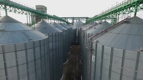Aerial. Agriculture grain silos storage tank.  Flying near silos tanks 