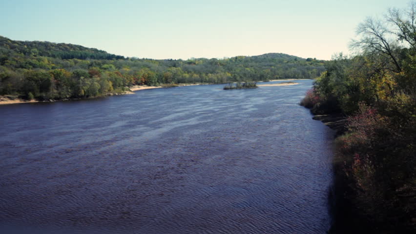 The Wisconsin River surrounded by autumn foliage, view from a bridge