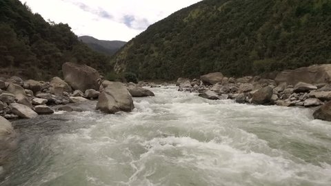 Aerial - Slow motion flying low up a river rapid - New Zealand