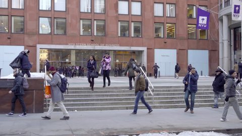 NEW YORK - FEB 15, 2017: Female Students Walking Down Steps Exiting NYU Stern School Of Business Front Entrance Cold Winter Day 4K NYC. NYU is a world renowned educational institution in the city.