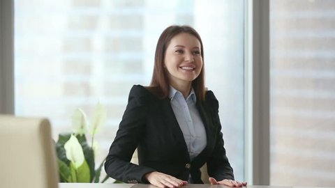 Young happy beautiful businesswoman wearing formal suit meeting casual client at modern office. Negotiations and work with documents between colleagues or partners. Young man choosing consultant