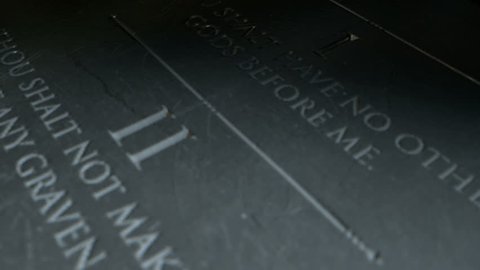A slow close up pan across a stone tablet with the second five of the ten commandments inscribed onto them