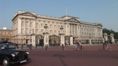 London, England - CIRCA June, 2006: Traffic passes by the camera as Buckingham Palace sits in the background