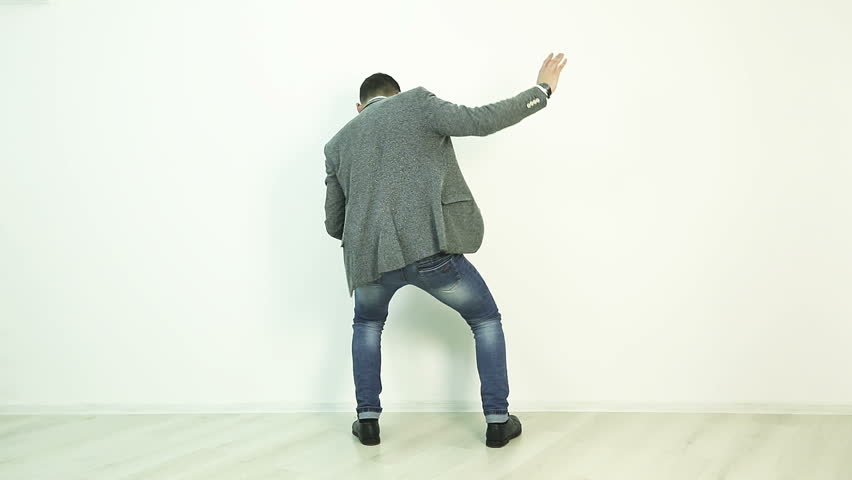 Slow motion. A young businessman holds a tablet in his hands and dances.