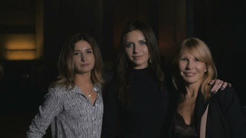 Three pretty women shows a thumb into the camera