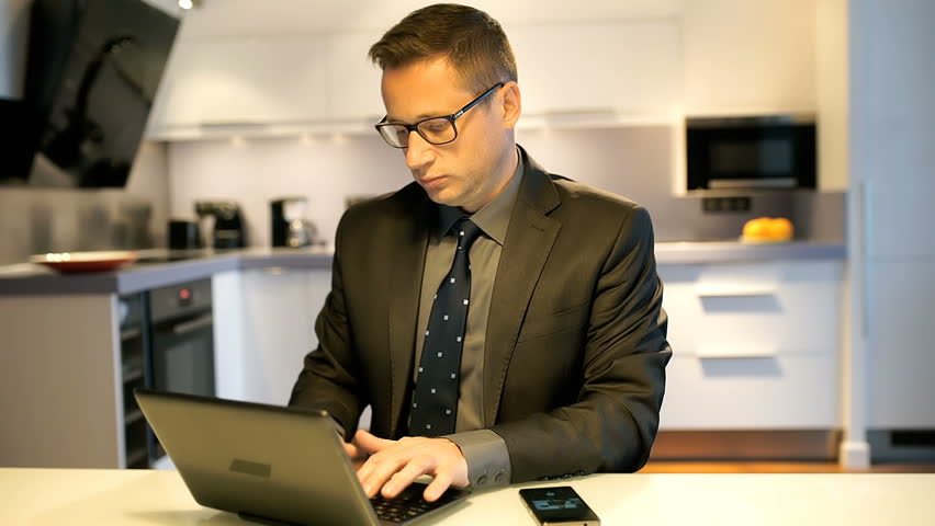 Businesswoman working on laptop in the kitchen and having a success
