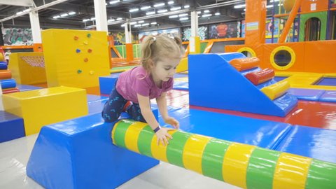 SAMARA, RUSSIA - February 9, 2017  Little girl Playing In Indoors Playground. Active Toddler Girl Having Fun At Sport Center.