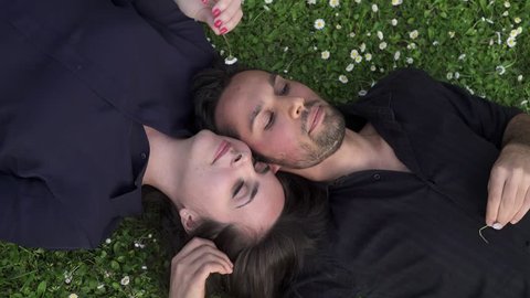 pair of lovers lying on the grass chatting amiably