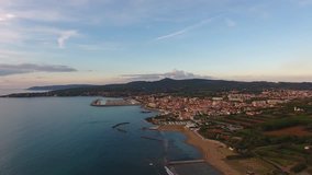 Aerial shot, incredibly beautiful calm sea in Italy in the sunset light with lots of clouds, filmed with drone, 4K