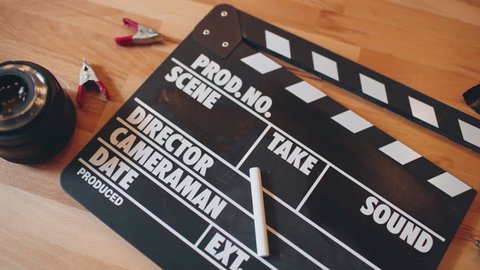 Movie slate and gadgets on wooden table. 4K UHD video.