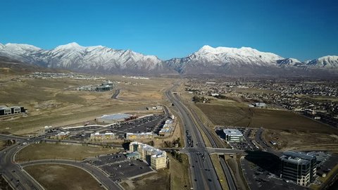 LEHI, UTAH - ,AR 2017: Aerial high tech business Utah mountain valley traffic. Freeway intersection with crossing roads. Busy commuter traffic at end of work day. Car, truck, bus vehicles.